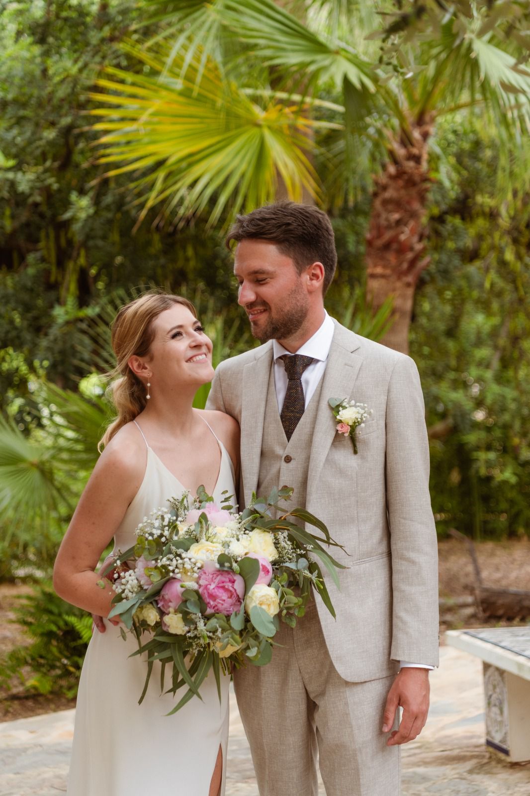 Newlywed couple celebrating, groom in a handcrafted Atelier ACÀN tuxedo. Client stories at Atelier ACÀN.