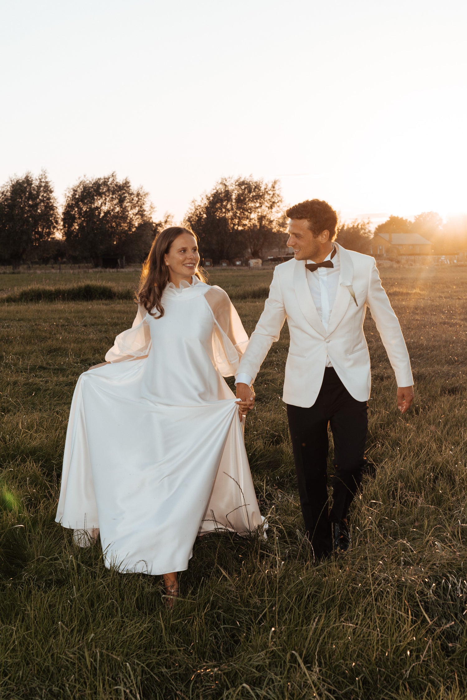 Newlywed couple celebrating, groom in a handcrafted Atelier ACÀN tuxedo. Client stories at Atelier ACÀN.