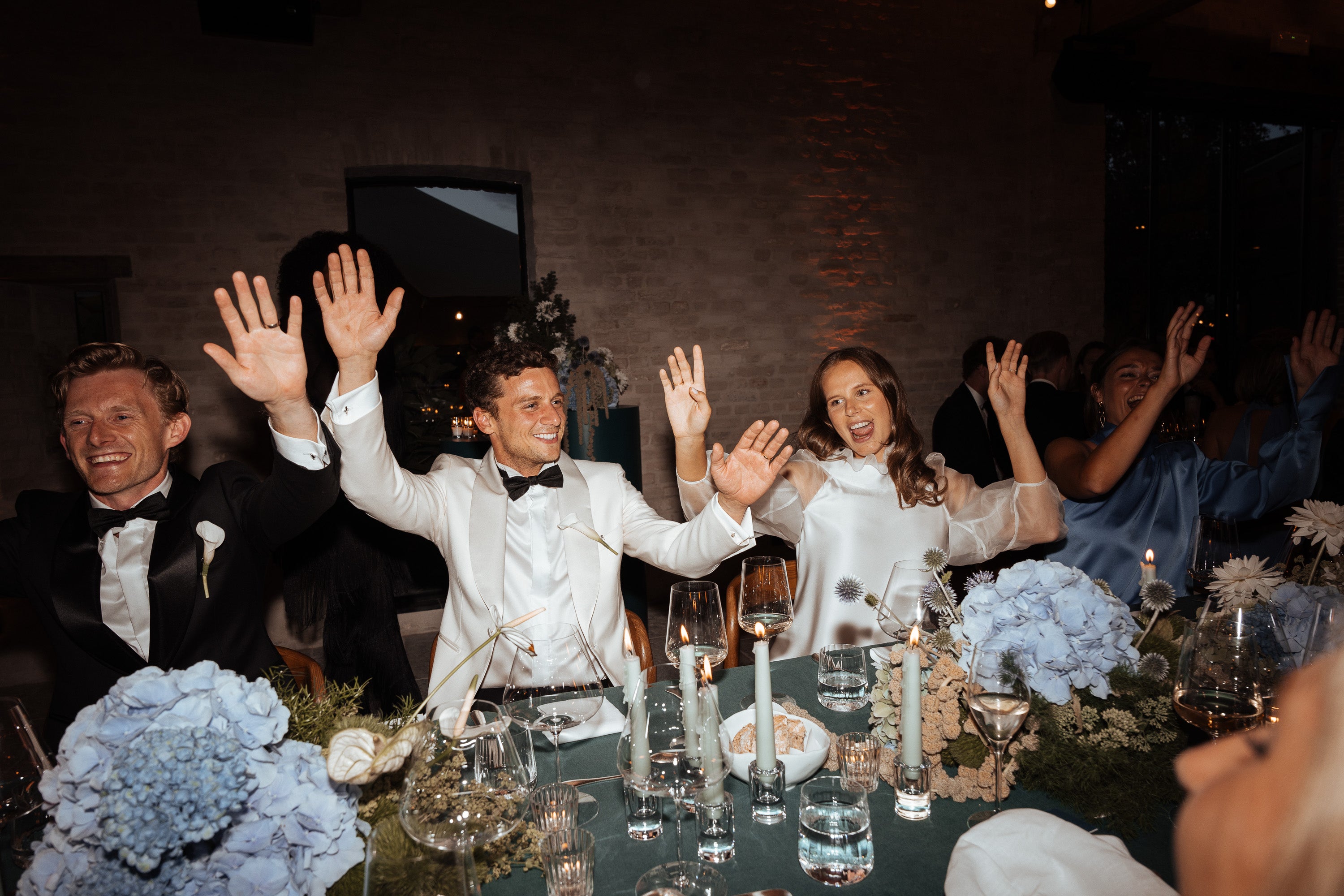 Newlywed couple celebrating, groom in a handcrafted Atelier ACÀN tuxedo.