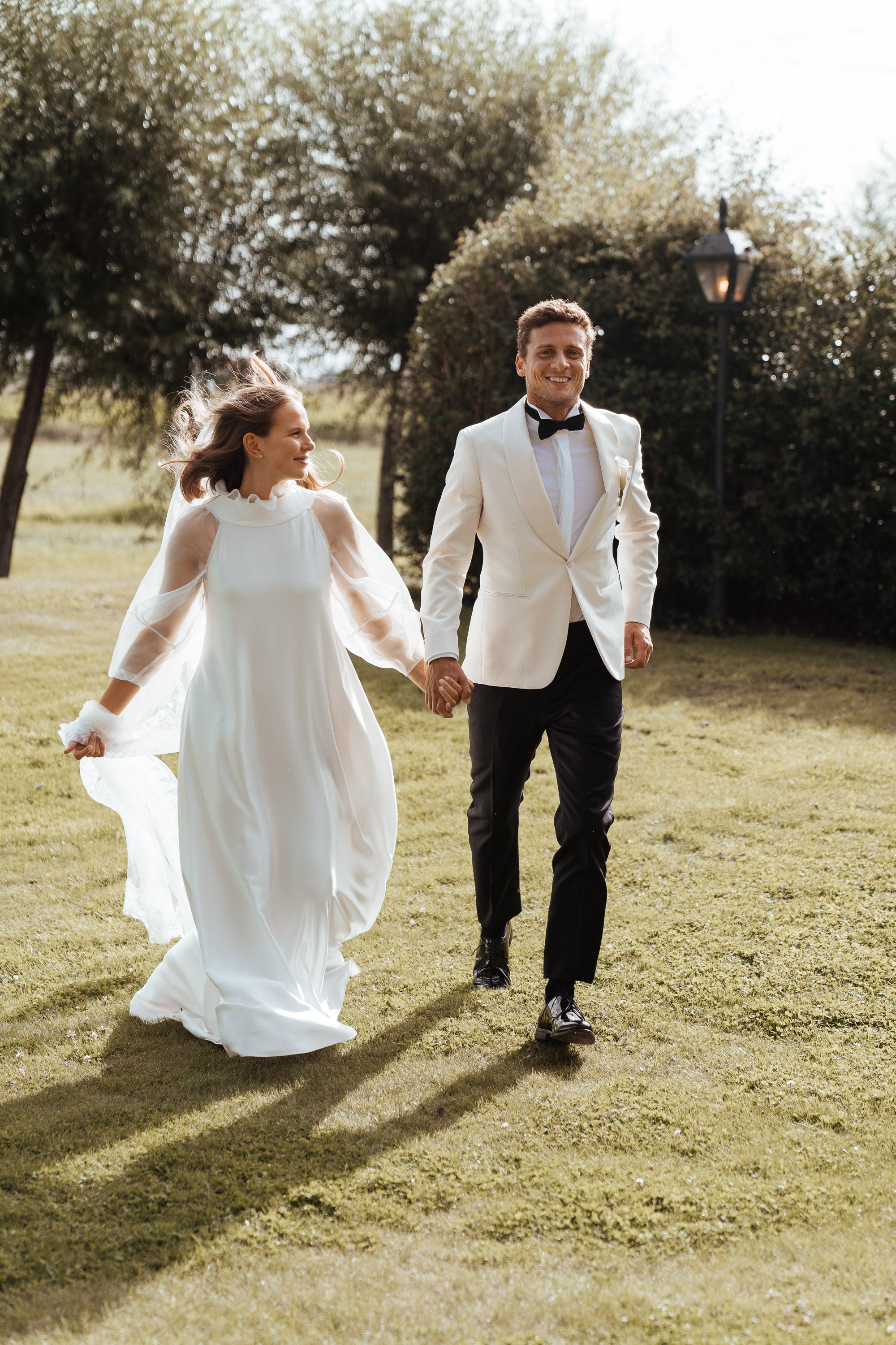 Newlywed couple celebrating, groom in a handcrafted Atelier ACÀN tuxedo. Client stories at Atelier ACÀN.